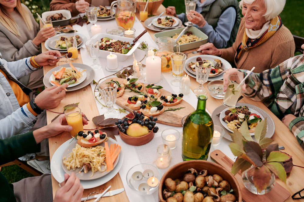 Group of people enjoying a meal together at a table with various dishes and drinks.