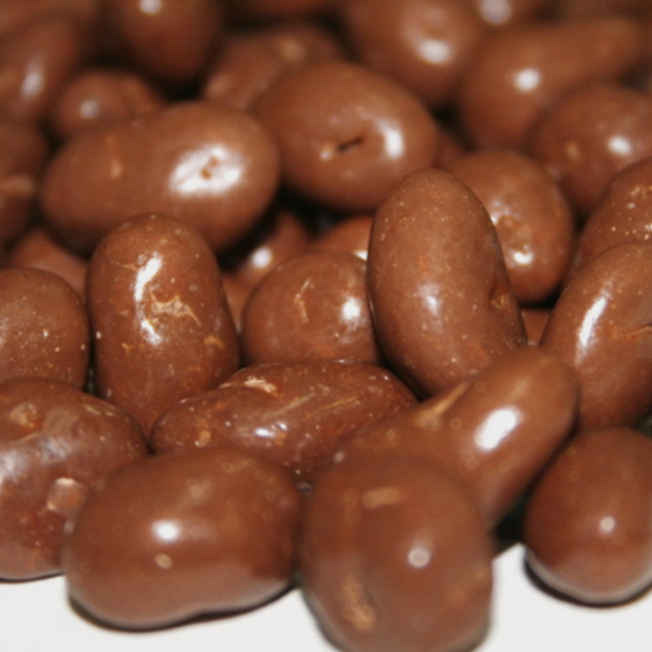 Close-up of chocolate-coated almonds on a white background