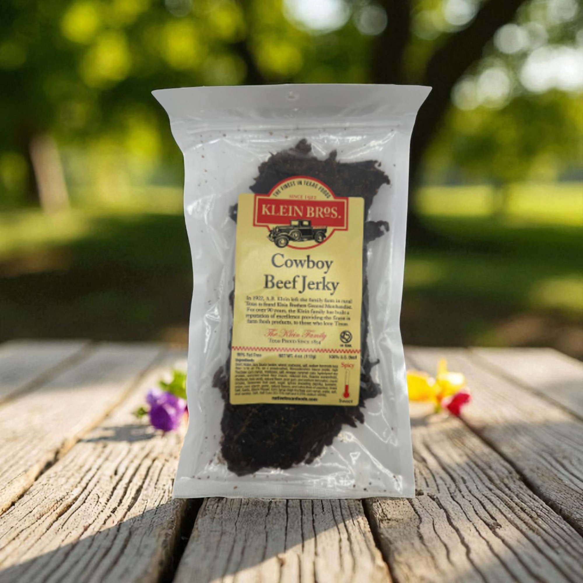 Package of Klein Bros Cowboy Beef Jerky on a wooden surface with a blurred natural background