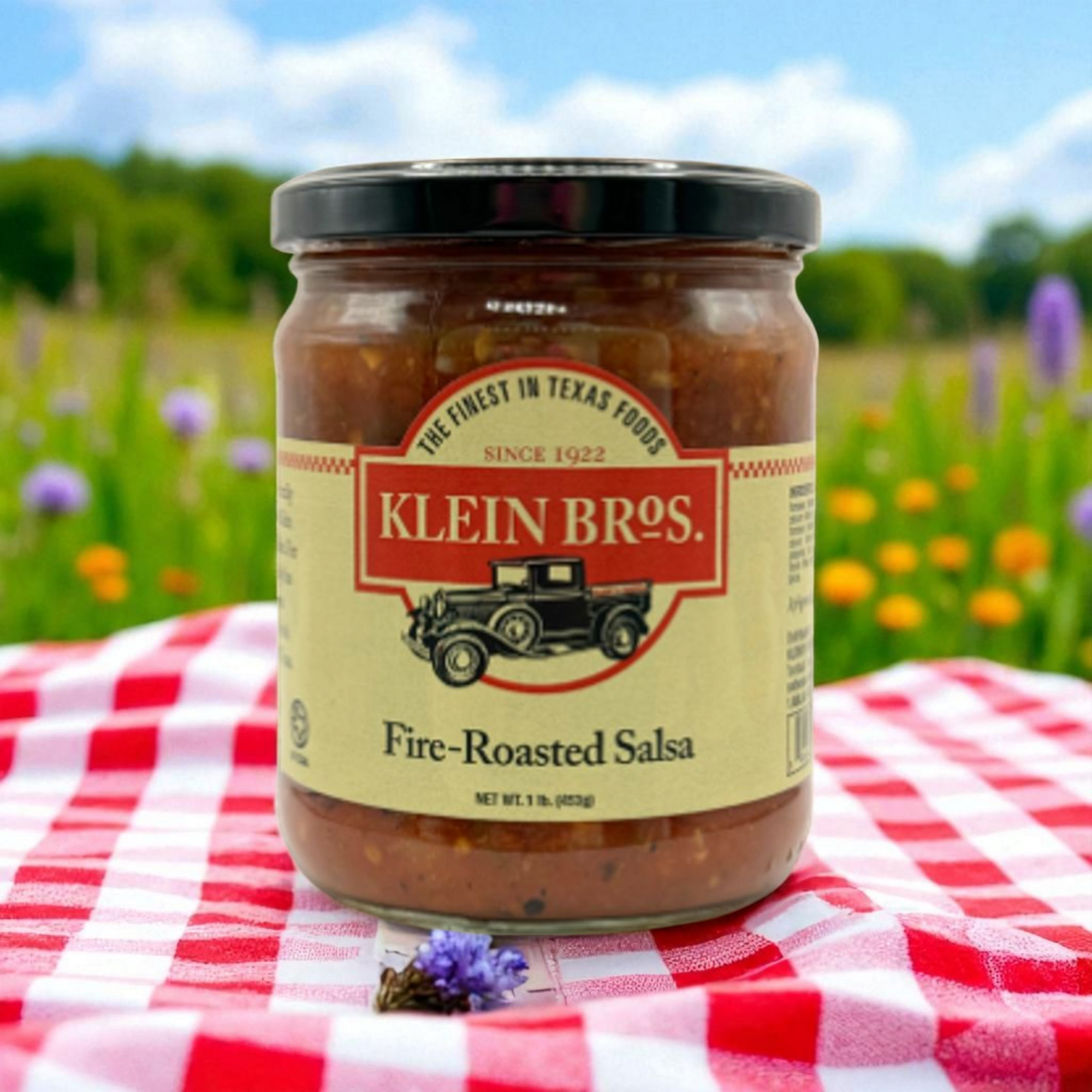 Jar of Klein Bros. Fire-Roasted Salsa on a red and white checkered tablecloth with a natural background