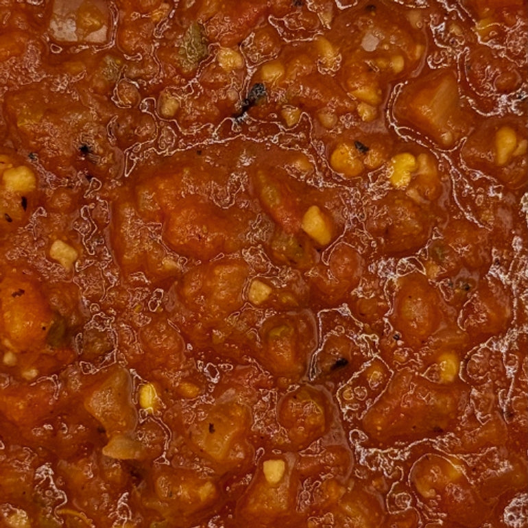 Close-up of a red sauce with chunks of vegetables