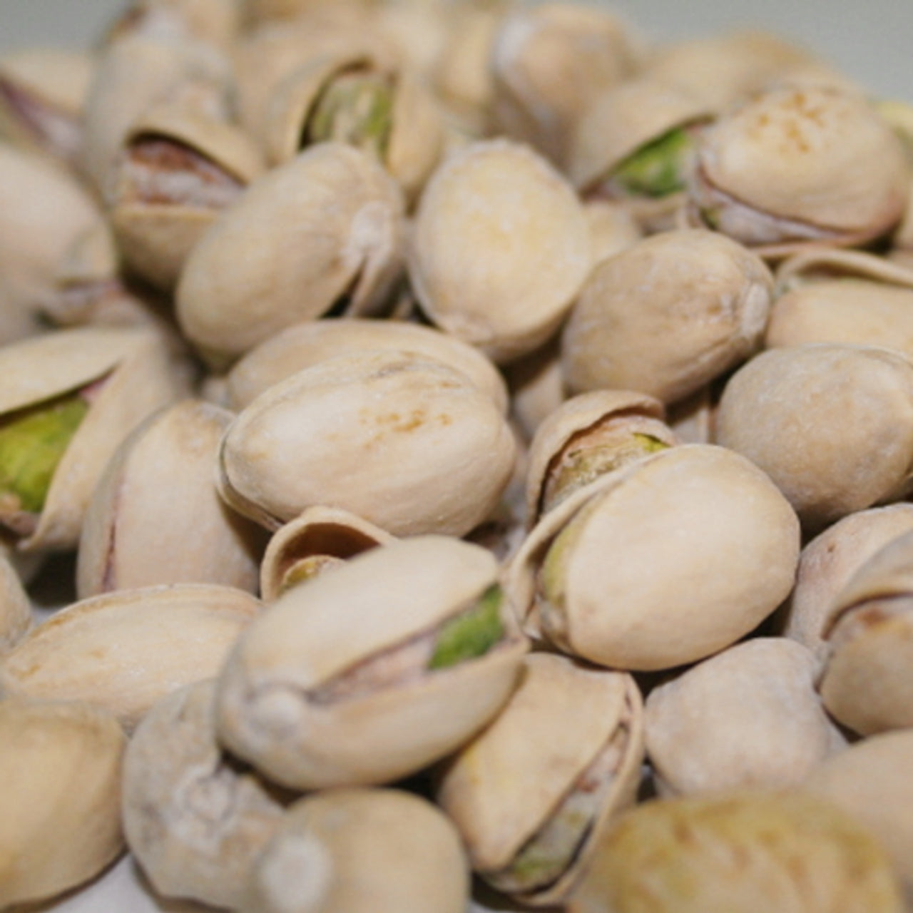 Close-up of pistachios with shells on a white background