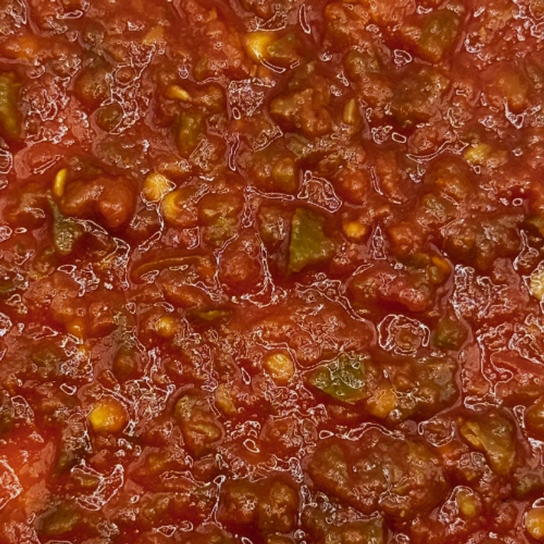 Close-up of a red salsa with visible chunks of tomatoes and peppers.