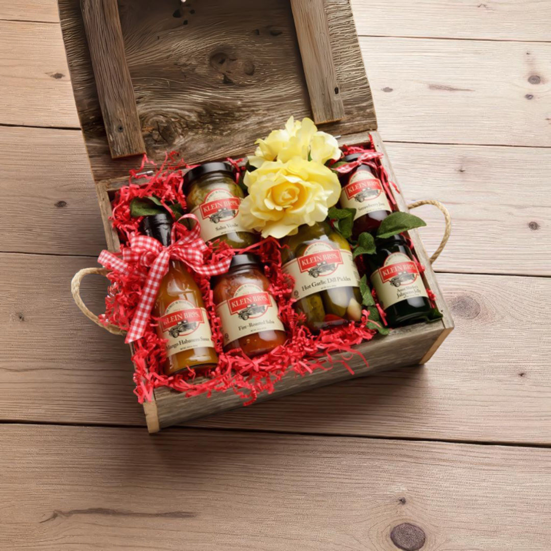 Gift set with mini bottles and a yellow flower in a wooden box on a wooden surface